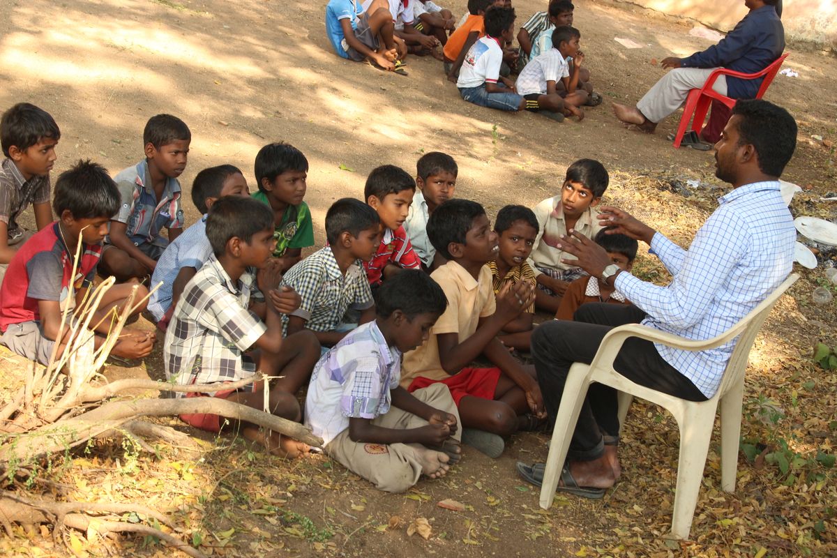 Volunteers and evangelists sharing the gospel message in an open-air community gathering
